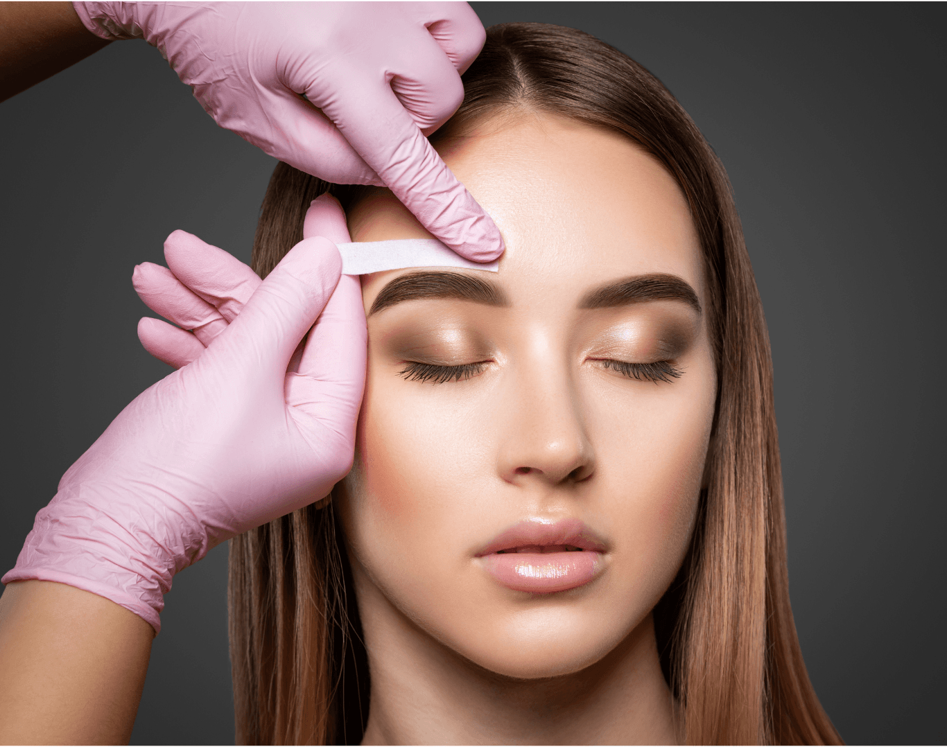 Beauty therapist using a wax strip to shape a client's brows during an eyebrow wax at Directors Cut Hair, Nails and Beauty, Crystal Peaks, Sheffield