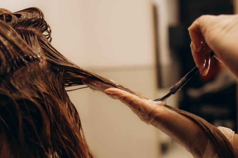 Hairdresser applying hair colour treatment with a brush at Director’s Cut Hairdressing in Crystal Peaks, Sheffield.