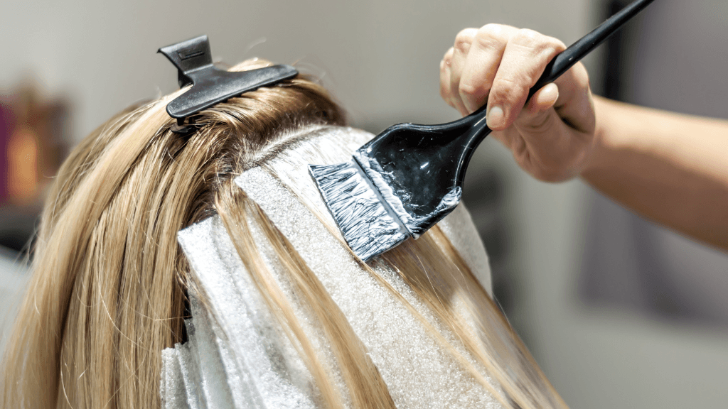 Hairdresser applying highlights with foils and brush at Director’s Cut Hairdressing in Crystal Peaks, Sheffield.