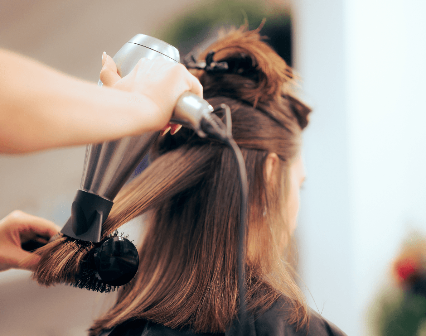 Professional stylist blow-drying a client’s hair after a shampoo at Directors Cut Hair, Nails and Beauty, Crystal Peaks, Sheffield